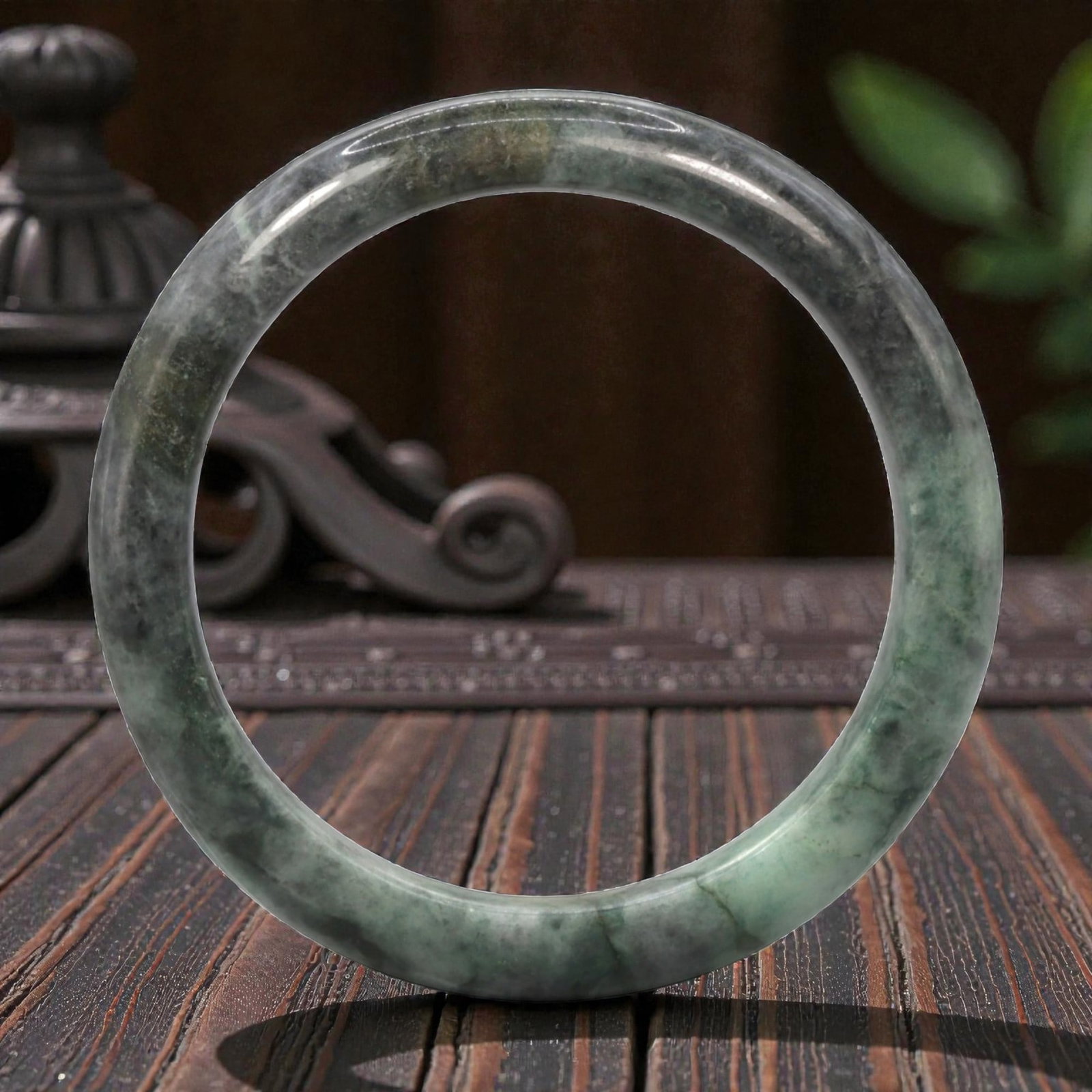 Natural Burmese Type A Jadeite Jade Bangle Bracelet, 20th Century, 75ZK: Carved from jadeite jade with a variegated palette of pale green and deep greyish-black mottling throughout, the bangle is formed as a continuous circular band with a rounded cross-section. The surfac