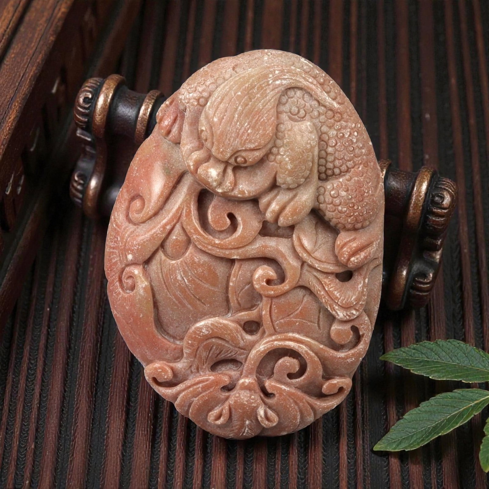 A Chinese Hardstone Plaque Carved with a Mythical Beast and Scrollwork Pendant, 3FD: Carved from reddish-brown hardstone with subtle tonal variations and a matte-to-softly polished surface, the plaque is worked in openwork and high relief with a dynamic composition of a mythical beast