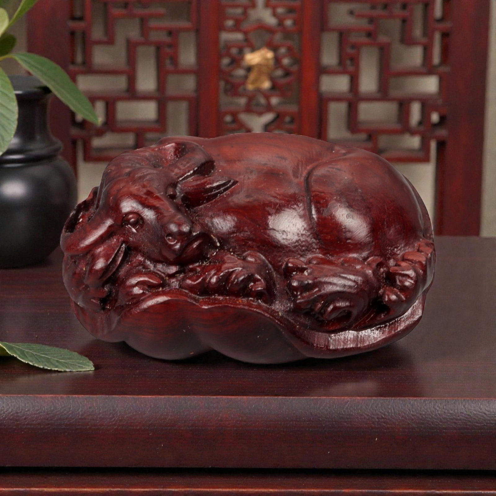 A Chinese Wood Buffalo Carving, 20th Century, 51YB: Carved from dense reddish-brown wood with a smoothly polished surface and visible natural grain, the figure represents a water buffalo shown recumbent with the legs tucked beneath the body and the hea