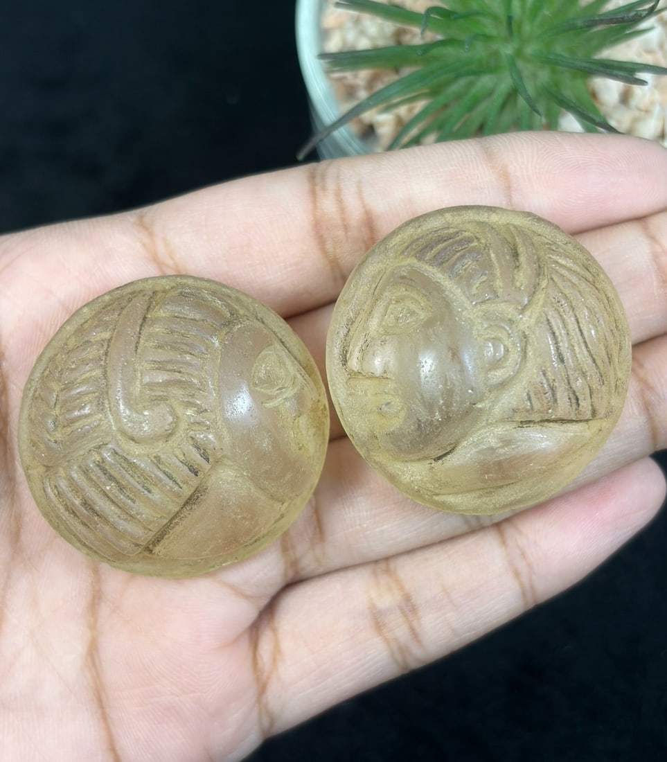 Lot Of 2 Antique Egyptian Glass Intaglio with Profile Head Motif, 67AR: Each circular example is hand-carved from translucent ancient glass, featuring relief incised profile human heads with meticulously detailed patterned hair and defined facial features executed in Egyp
