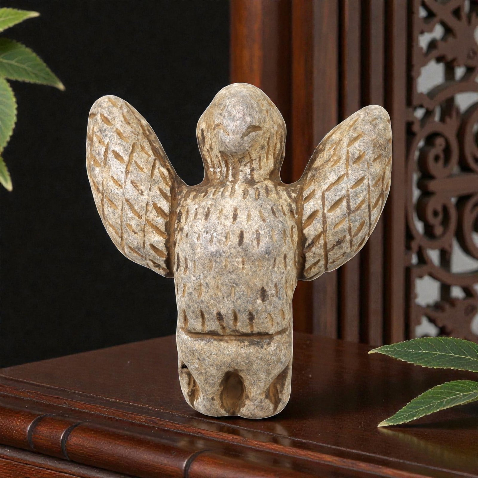 Ancient Stone Vulture Amulet - Near Eastern Avian Figure, 36AN: This vulture amulet is carved from light speckled stone, depicting a stylized vulture with outstretched wings and a compact, rounded body. The piece features incised linear and stippled detailing to d
