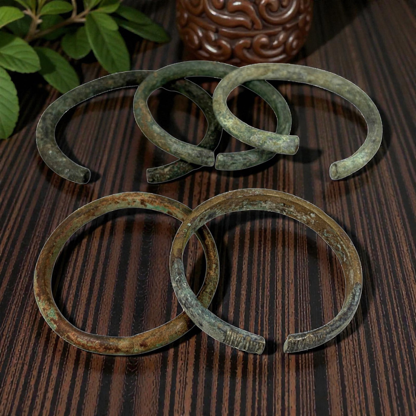 Lot of 5 Roman Bronze Bracelets, Circa 1st-4th Century CE, 91AG: A group of five open-ended bracelets crafted from bronze, exhibiting varied patination including deep green verdigris, brown oxidation, and lighter greyish surface deposits, consistent with archaeolog