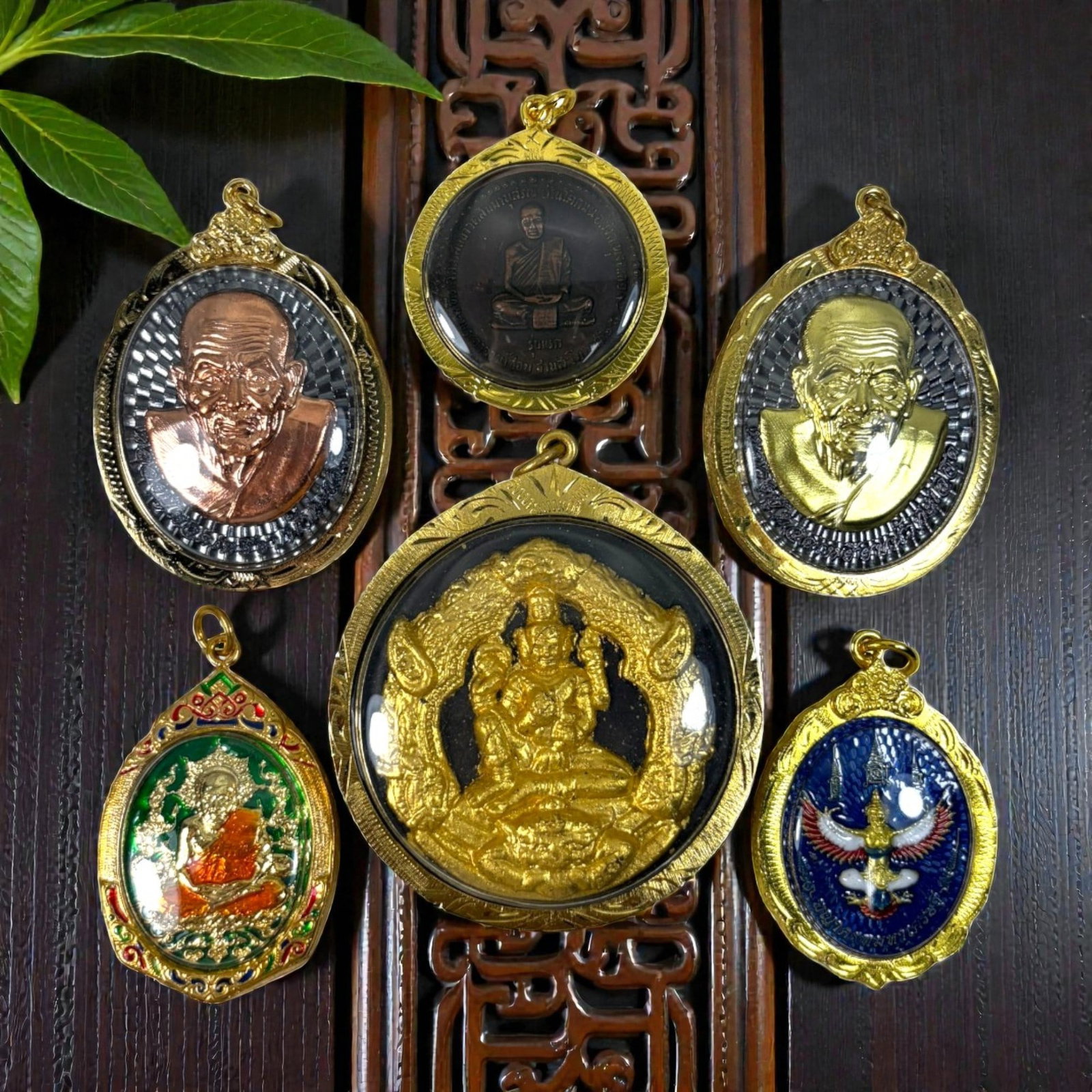 A Lot of 6 Vintage Gilt Thai Buddhist Amulets with Enamel Accents, 43AA: Comprising six pendants of varying shapes and sizes, ranging from 4.5 to 7 cm in height. Each amulet is encased in ornate gilt metal frames, several accented with colorful enamelwork. The group includ