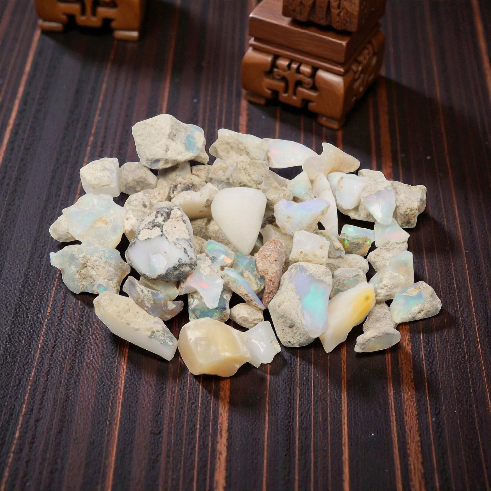 An Ethiopian Welo Opal Rough Lot, 47.23g, 50ZH: A parcel of rough Welo opal, with individual pieces ranging from 1-2 cm in size. The specimens exhibit a milky to translucent base, with visible play-of-color displaying flashes of blue, green, yellow