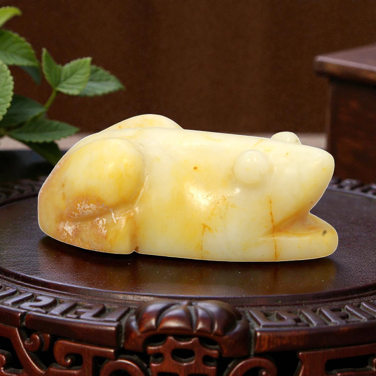 A Chinese Hetian Jade Frog Figure, 20th Century, 46FH: Carved from pale creamy-white Hetian jade with areas of natural yellow and russet staining, the figure is modeled as a recumbent frog shown resting with its body flattened close to the ground. The hea