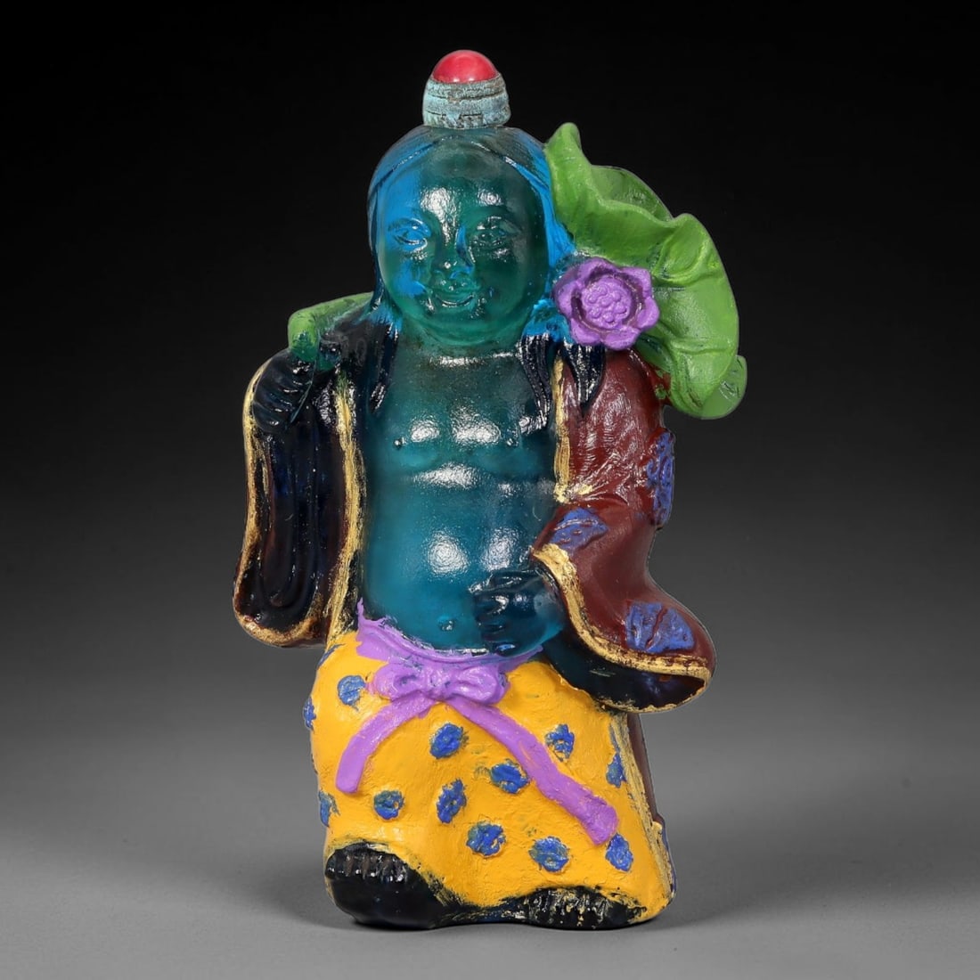 Vintage Chinese Liuli Glass Snuff Bottle - Figure With Lotus Leaf Motif, 60YF: This snuff bottle is moulded from translucent teal liuli glass, shaped as a traditional Chinese figure adorned with a sculpted green lotus leaf and purple blossom resting over one shoulder. The form f