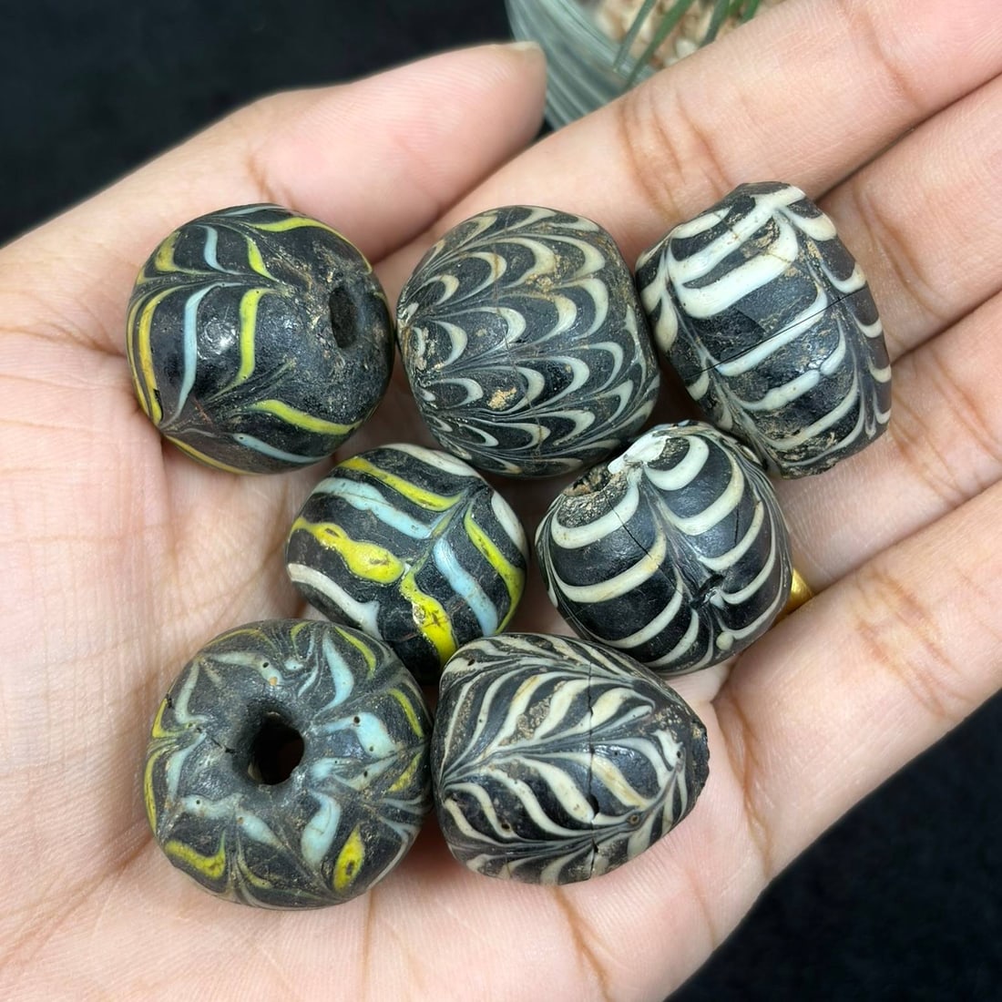 Lot of 7 Antique Islamic Glass Beads, Circa 9th-14th Century, 16AS: This set includes seven patterned glass beads individually measuring 2 cm each, produced in a stylistic revival referencing medieval Islamic feather-pattern trade glass beadwork techniques. Each bead 