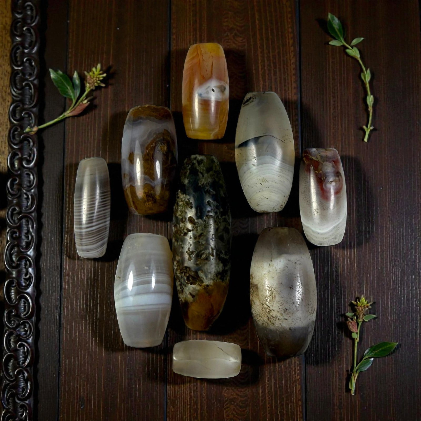 A Lot of 9 Himalayan Banded Agate Beads, Ancient to Antique Period, 17YD: Comprising lot of barrel and ovoid beads, each carved from banded agate with natural tonal variations, many displaying characteristic concentric, linear, and dendritic patterns. The surfaces exhibit s