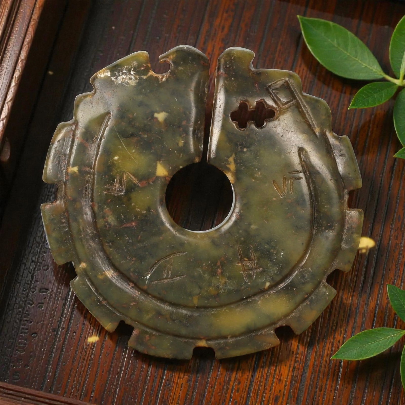 A Chinese Hardstone Bi-Form Disc, Reverse Side, Possibly Late Qing to Early Republic Period, 87FC: The reverse of the hardstone bi-form disc reveals the mottled olive-green stone with scattered russet, yellow, and darker mineral inclusions more prominently, largely left undecorated to emphasize the