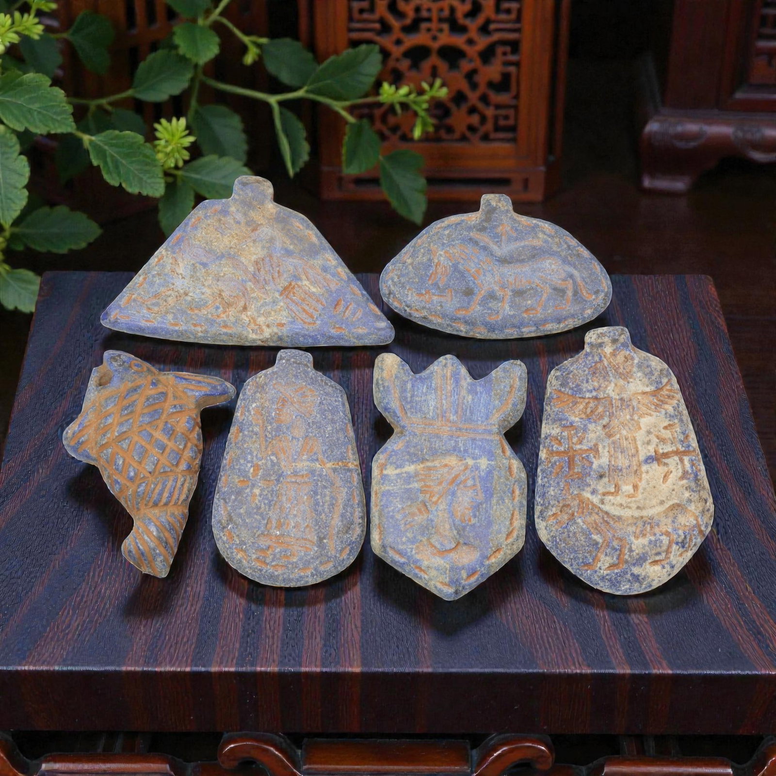 A Lot of 6 Ancient Near Eastern Lapis Lazuli Amulets, Circa Late Bronze to Iron Age, 2WS: Carved from lapis lazuli, the group consists of six distinct amulets of varied forms. The set includes a triangular pendant with a winged quadruped motif, a semi-oval pendant with a lion-like creature