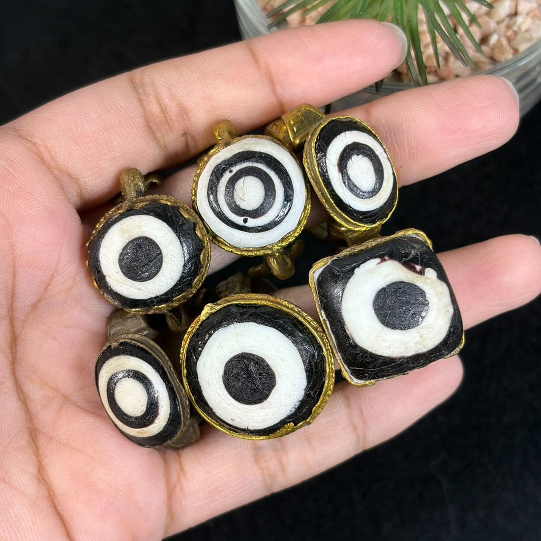 Vintage Qajar Style Gilt Black White Evil Eye Glass Inlay Rings Lot, 93AS: This six-piece lot contains untested gilt alloy adjustable rings crafted in traditional Qajar Persian tribal design, each set with hand-formed black and white concentric evil eye glass cabochons in ov