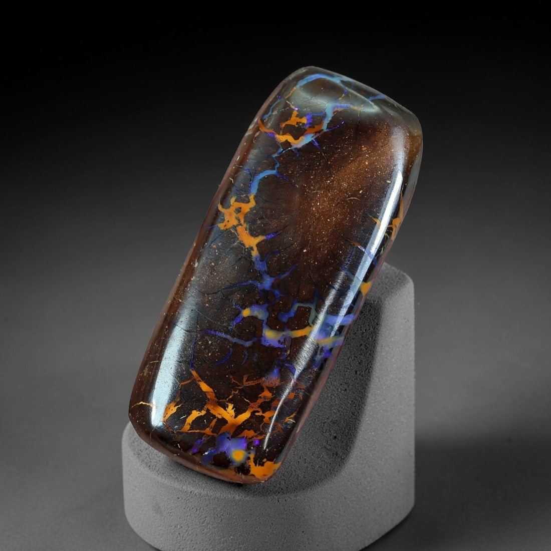 21.37ct Natural Australian Queensland Matrix Boulder Opal Cabochon, 68AT: Hand polished elongated rectangular bar cabochon of natural Queensland matrix boulder opal, formed with rich dark ironstone host matrix interlaced with branching opal veins blending vivid violet-blue 