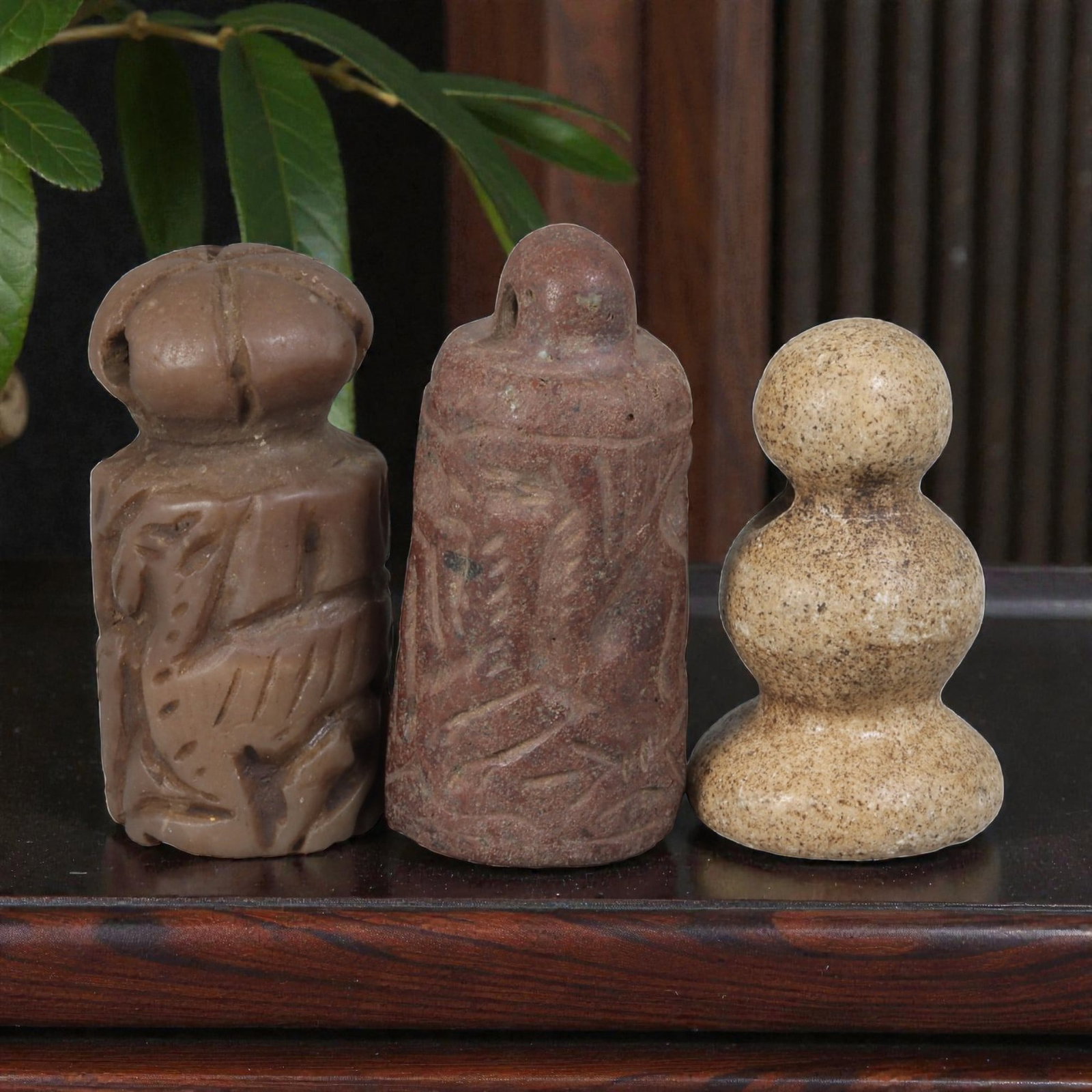 Lot of 3 Ancient Mesopotamian Cylinder Seal and Stamps, 79WM: A collection of three ancient Mesopotamian stone seals and stamps, carved from brown and light-toned stone. The set includes: a reddish-brown cylinder seal engraved with zoomorphic motifs, a carved br