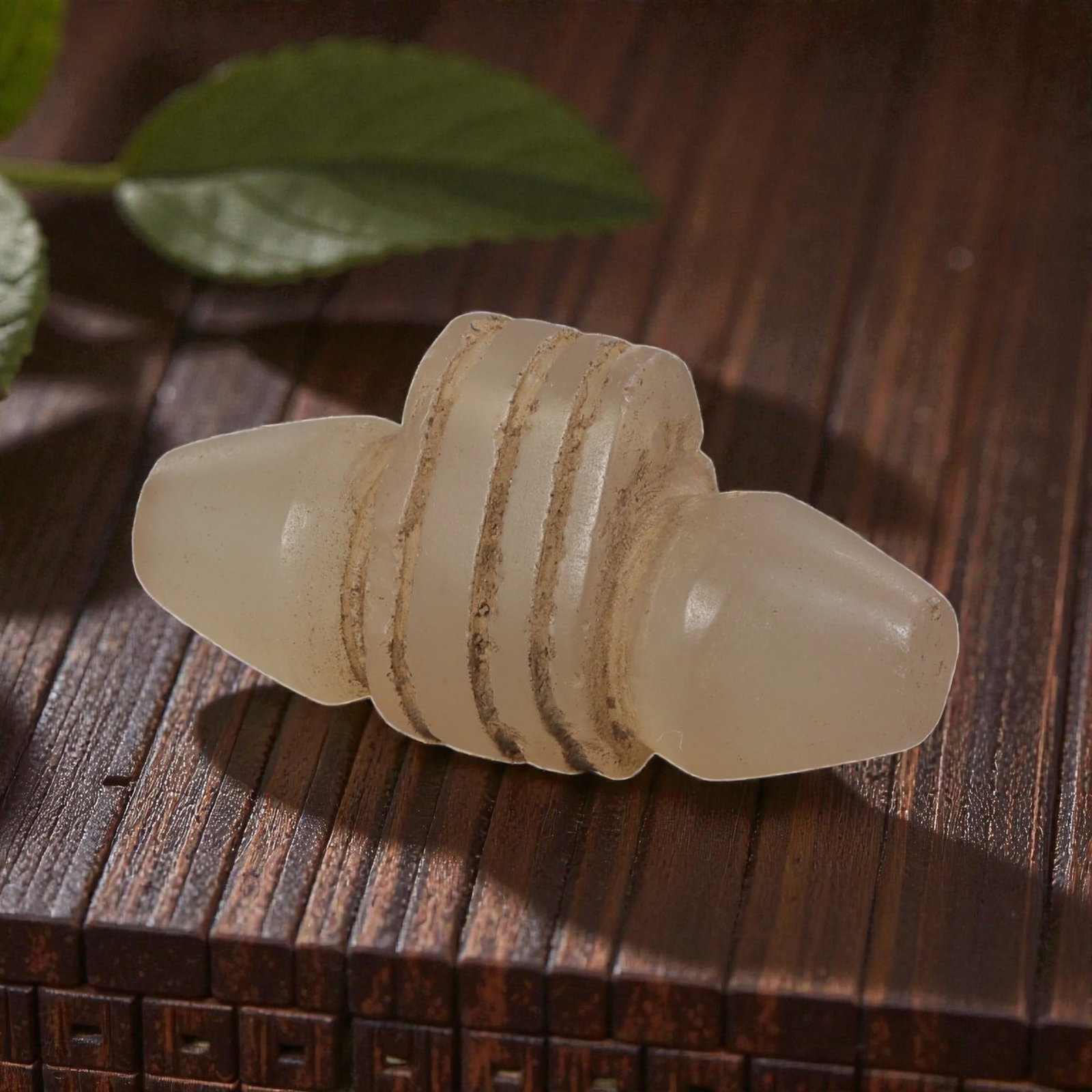 Ancient Coptic Egyptian Glass Amulet, Roman to Coptic Era, 86YD: This ancient amulet is formed from translucent pale glass, shaped into a symmetrical, double-conical form with raised horizontal bands encircling the central body. The surface displays an aged patina 
