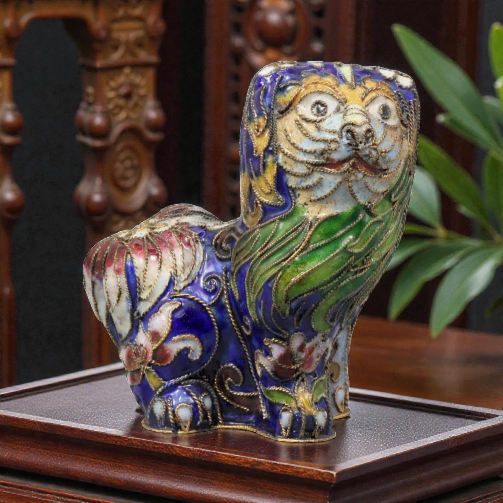 A Chinese Cloisonne Enamel Lion Effigy, 20th Century, 72YC: Constructed in copper and decorated with polychrome cloisonne enamel, the figure represents a stylized lion shown seated with the head turned slightly upward in an alert, expressive pose. The face is 