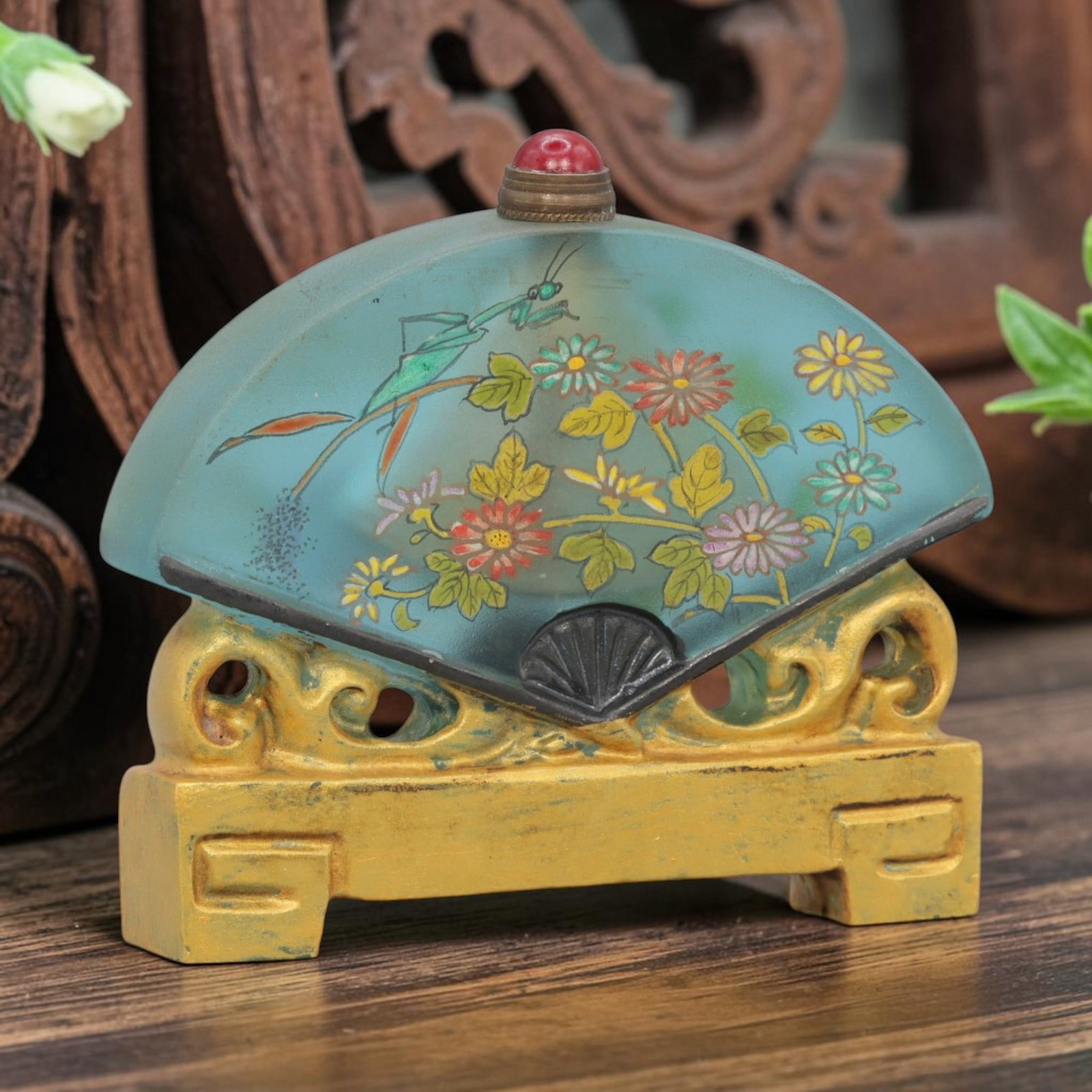 Vintage Chinese Reverse-Painted Liuli Snuff Bottle - Fan Form, 71YF: Crafted from frosted light blue liuli glass, this fan-shaped snuff bottle features intricate reverse-painted decoration depicting a mantis among flowering foliage. The translucent glass provides a sof