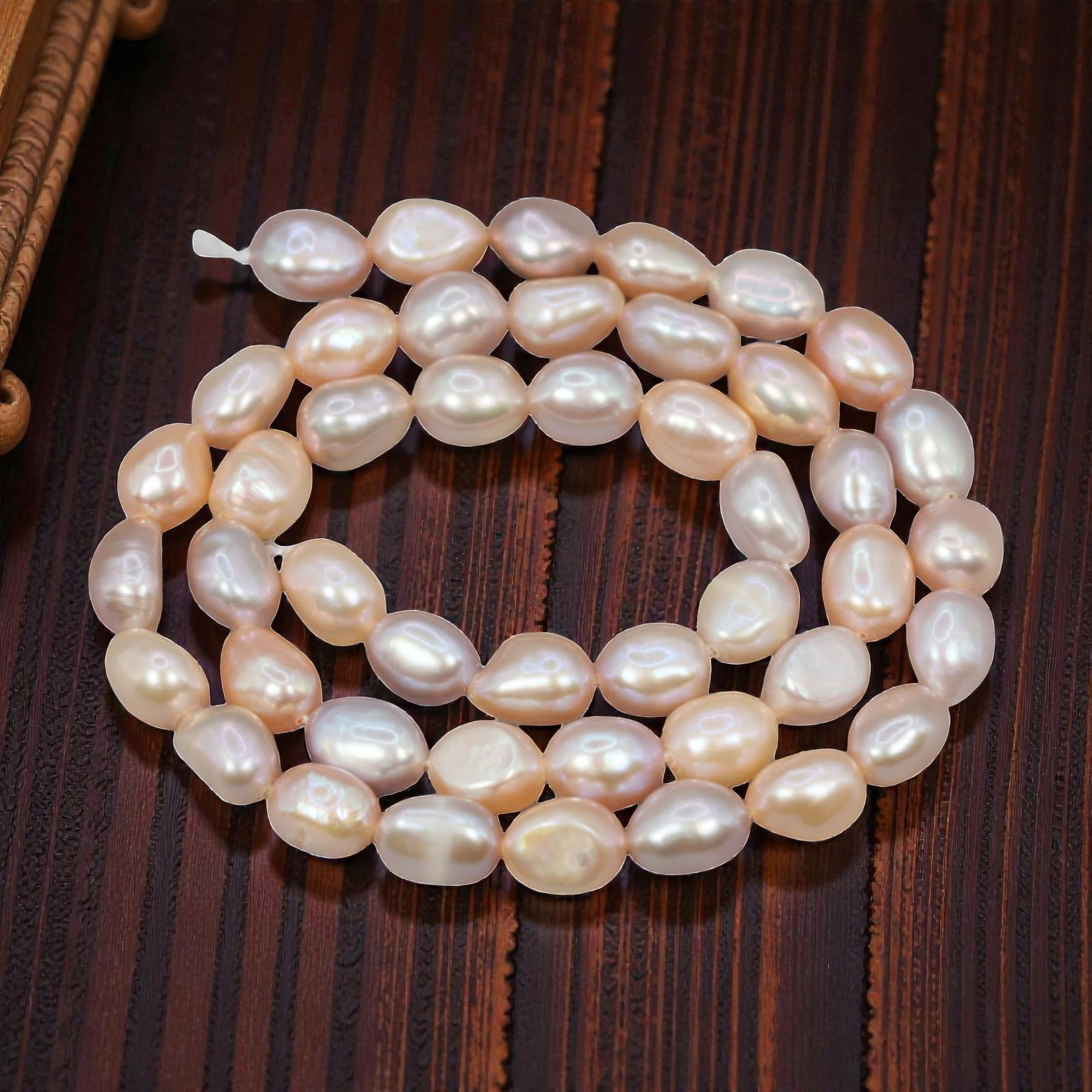 A Strand of Baroque Cultured Pearls, 20th Century, 83ZJ: Composed of baroque cultured pearls with a soft peach-pink body color and subtle iridescent overtones, the strand is strung in a single continuous line. Each pearl exhibits an irregular, slightly elon