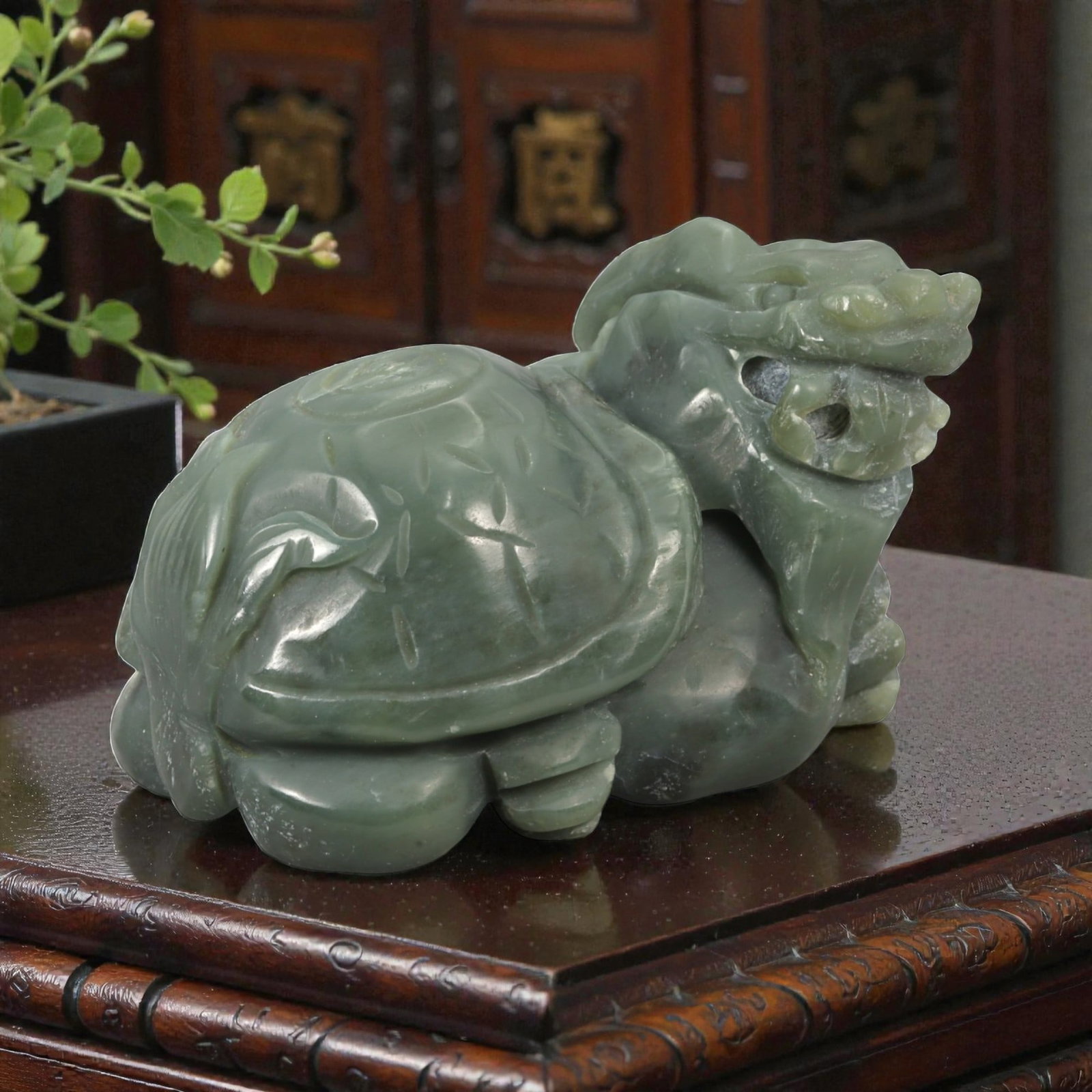 A Chinese Hetian Nephrite Jade Dragon Turtle (Bixi) Sculpture, 88YA: Carved from green jade with areas of darker and lighter tonal variation and natural translucency, the sculpture represents a dragon turtle (bixi) modeled fully in the round. The creature is shown in a