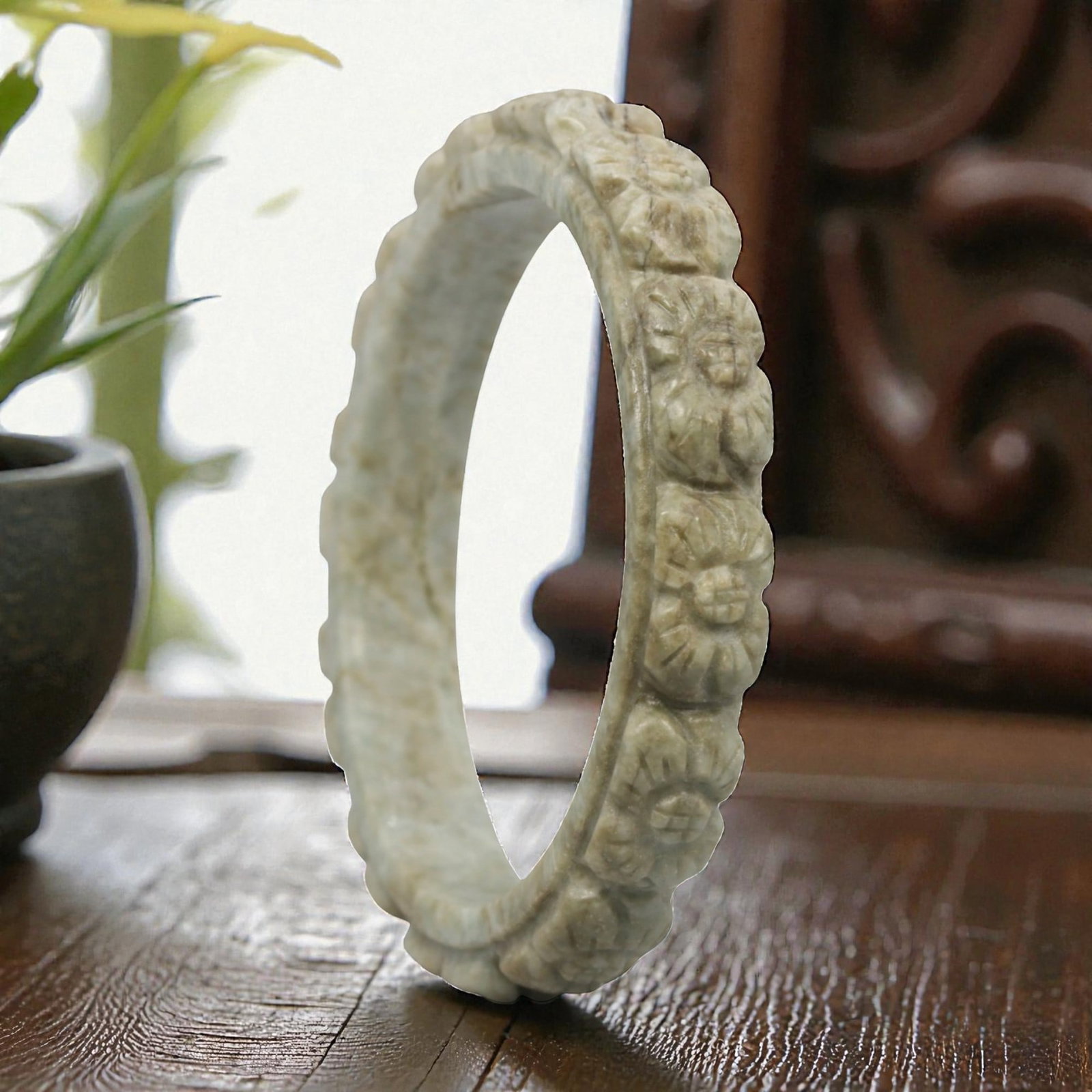 Natural Burmese Type A Carved Jadeite Jade Bangle Bracelet, 20th Century, 77ZL: A fine jadeite bangle of flattened circular form, masterfully carved in relief with a continuous band of chrysanthemum blossoms. The stone exhibits a pale milky-green base, accented by subtle brownish