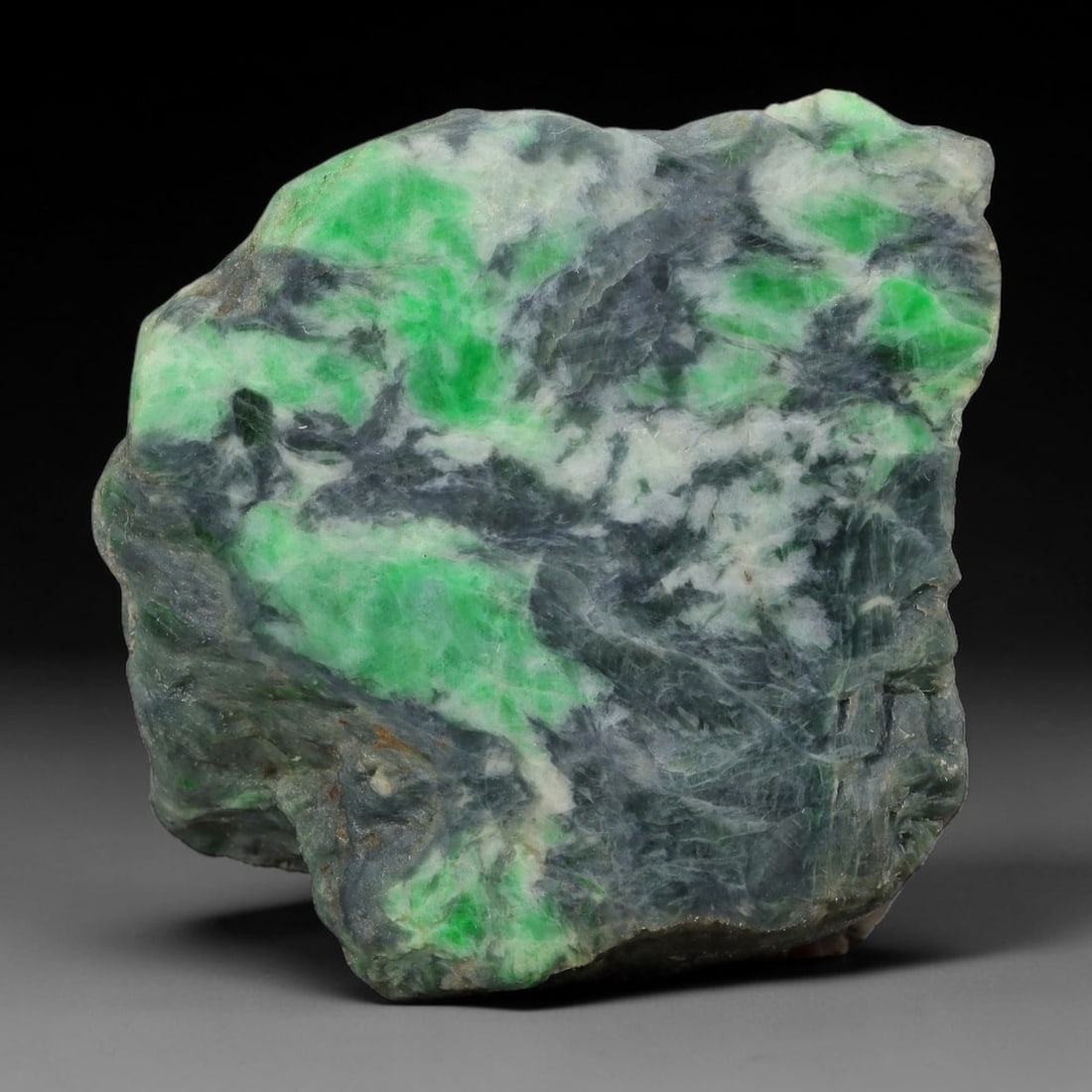 234ct Natural Type A Burmese Jadeite Jade Sliced Rough, 1YN: This specimen is a sliced rough block of natural Type A Burmese jadeite jade. The interior displays natural colour zoning with visible mineral veining and crystalline patterns typical of unprocessed j