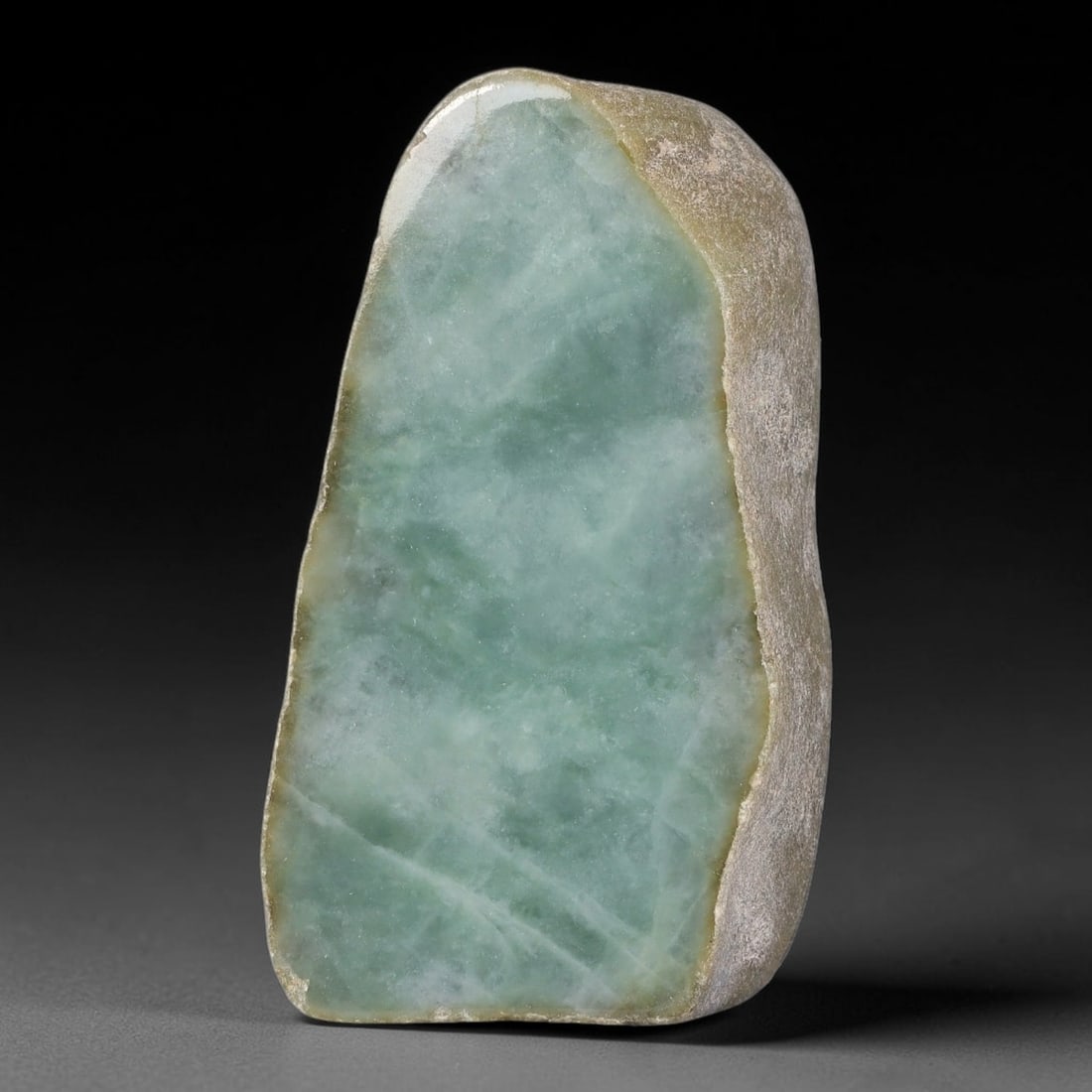 425ct Natural Type A Burmese Uniform Soft Sea Green Cloudy Jadeite Jade Sliced Rough, 9FA: This elongated sliced rough pebble is genuine untreated Type A Burmese jadeite, retaining partial naturally weathered pale tan outer skin running along its right-side perimeter edge. Its polished cut 