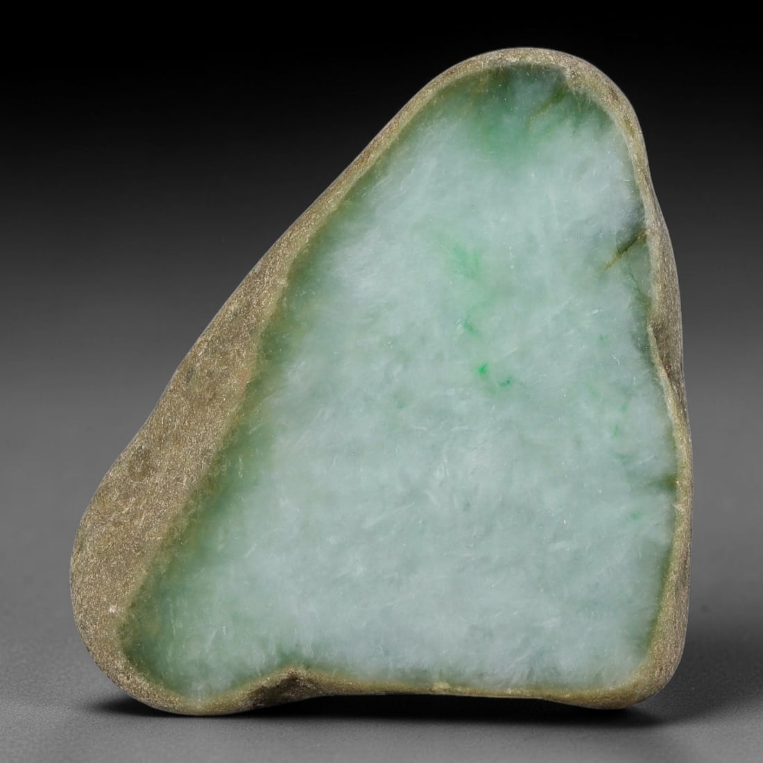480ct Natural Type A Burmese Pale Mint Green Floating Green Speck Jadeite Jade Sliced Rough, 11FA: This triangular natural split pebble is untreated Type A authentic Burmese jadeite, fully wrapped with naturally weathered tan outer skin around its entire perimeter edge. Its polished cut surface dis