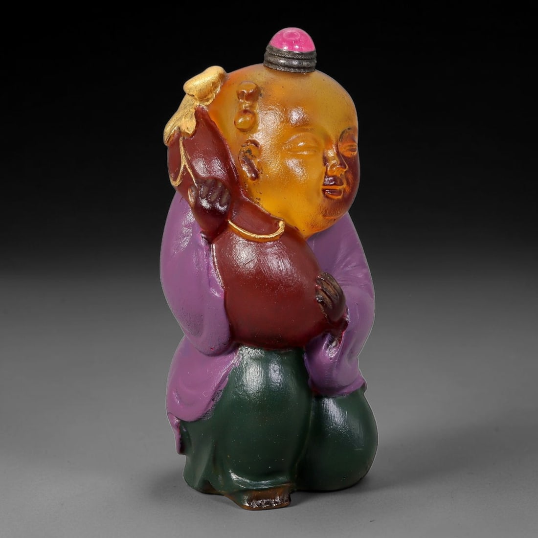 Vintage Chinese Liuli Glass Snuff Bottle - Boy Holding Gourd, 83YF: This snuff bottle is moulded from translucent amber liuli glass, shaped as a young boy clutching a reddish-brown gourd symbolizing good fortune. The garment is finished with hand-painted enamel in ric