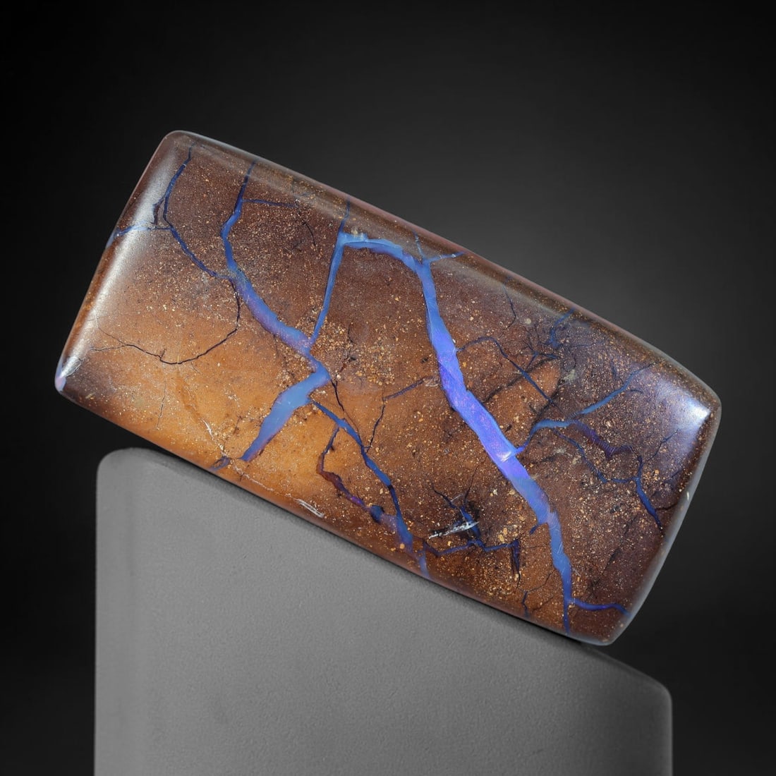 34.31ct Natural Australian Queensland Matrix Boulder Opal Cabochon, 20AV: Hand polished elongated rectangular bar cabochon of natural Queensland matrix boulder opal, showcasing warm gradient speckled ironstone matrix intersected by thick sweeping branching violet-blue opal 