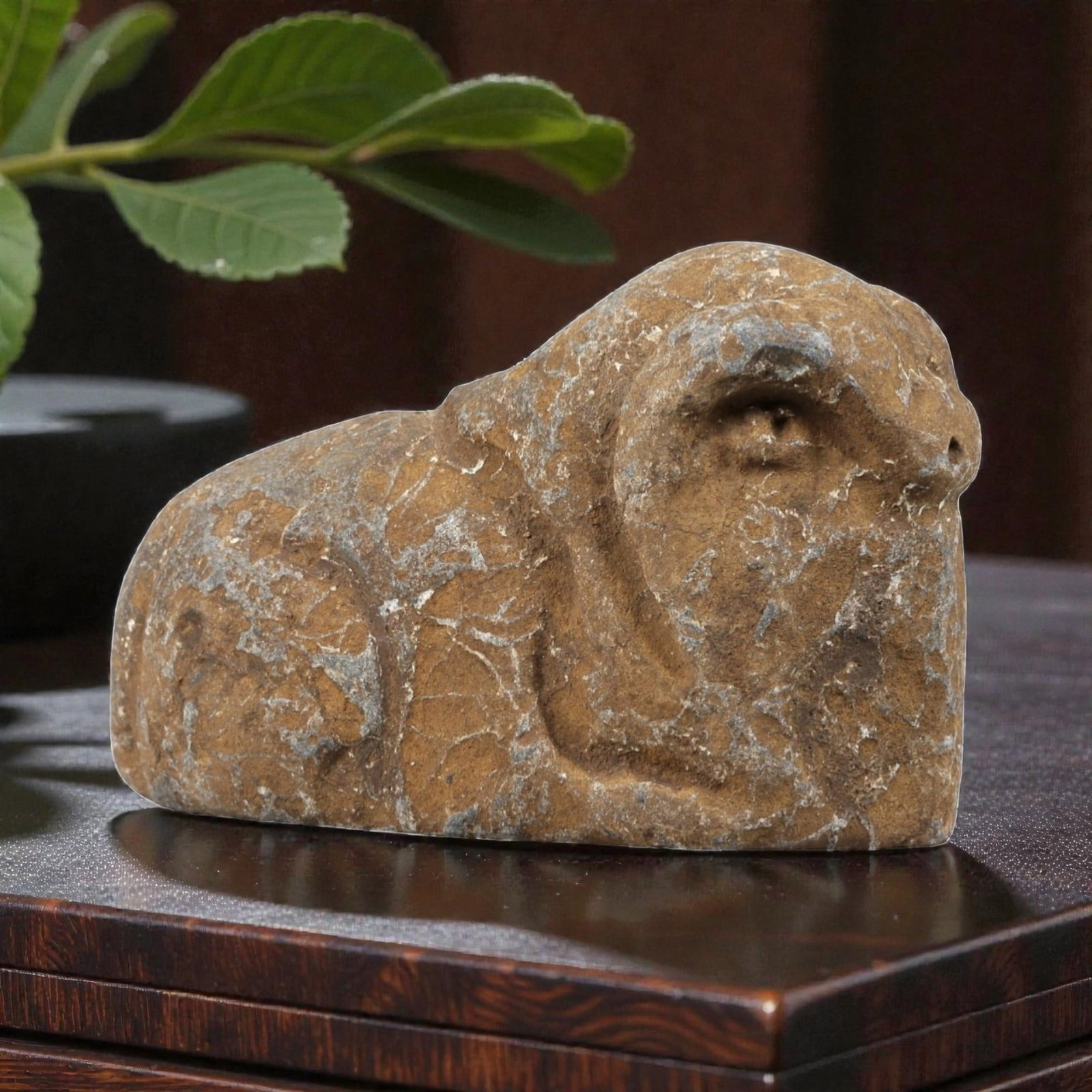Ancient Stone Ram Effigy - Near Eastern Zoomorphic Figurine, 97FX: Carved from a weathered, veined stone, this effigy depicts a recumbent ram in a compact, stylized form. Relief details define the curled horns, snout, and rounded body, emphasizing the animal's robust