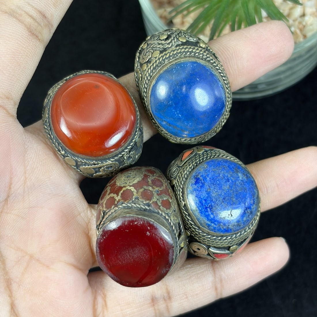 Vintage Central Asian Silvered Gilt Lapis Carnelian Inlay Rings Lot, 94AS: This four-piece grouping holds untested silvered alloy adjustable rings crafted in traditional Central Asian tribal craft, decorated with twisted wire filigree, brass gilt overlay scrollwork, and smal