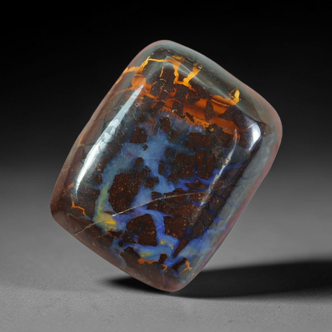 22.30ct Natural Australian Queensland Matrix Boulder Opal Cabochon, 73AT: This polished freeform cushion cabochon is natural Queensland matrix boulder opal, retaining dark ironstone host rock interlaced with vivid cobalt blue and warm golden orange opal veins. The domed sur