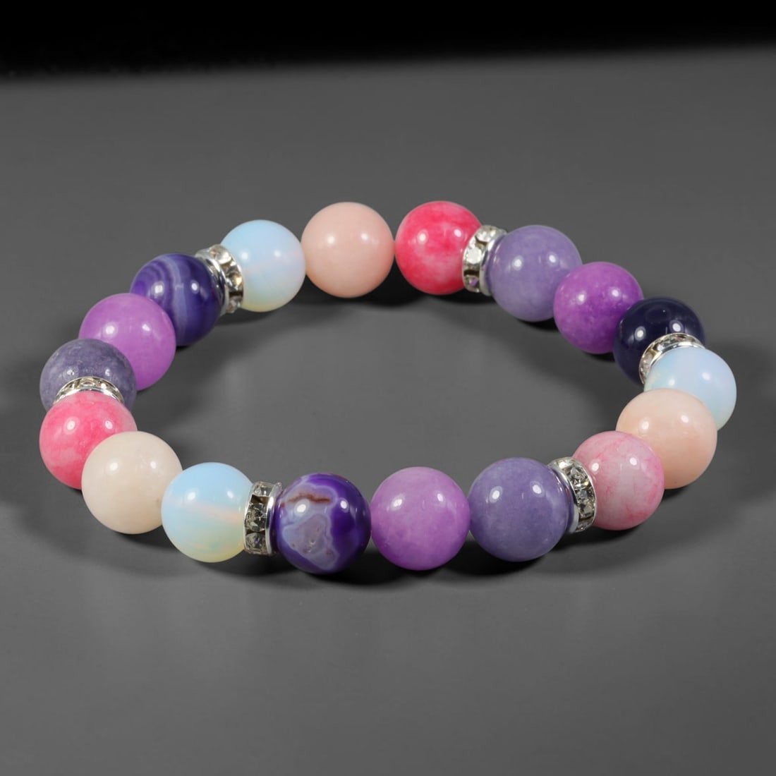 Natural Mixed Stone Beaded Bracelet - Polished Round Bead Strand, 39YM: This elastic stretch bracelet is made of uniformly spherical polished natural mineral beads with silvered metal spacers inlaid with clear crystalline accents. The stone exhibits multi-toned pastel and