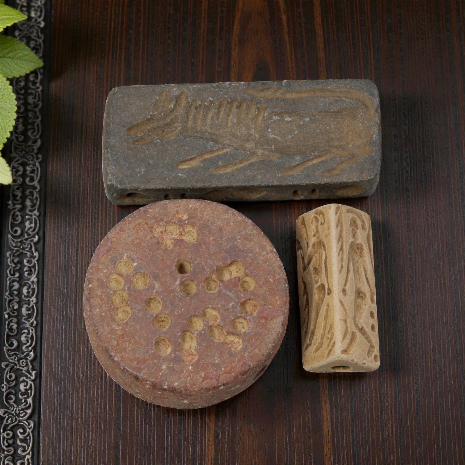 Lot of 3 Ancient Near Eastern Stone Seals / Artifacts, 8WT: A curated lot of three ancient Near Eastern-style stone artifacts, including a rectangular zoomorphic seal, a circular perforated disc, and a polygonal prism seal, all with natural patination and wear