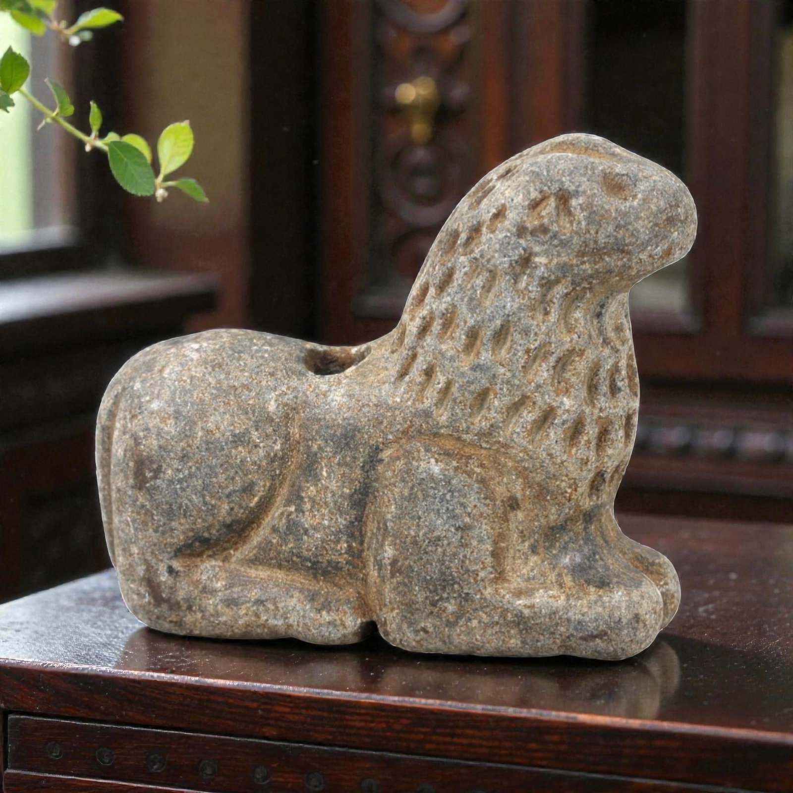 Ancient Stone Feline Amulet - Near Eastern Lion Effigy, 37AN: This amulet is carved from speckled grey stone, depicting a stylized lion in a recumbent, crouched posture. The piece features incised linear and stippled detailing defining the facial features, ears,