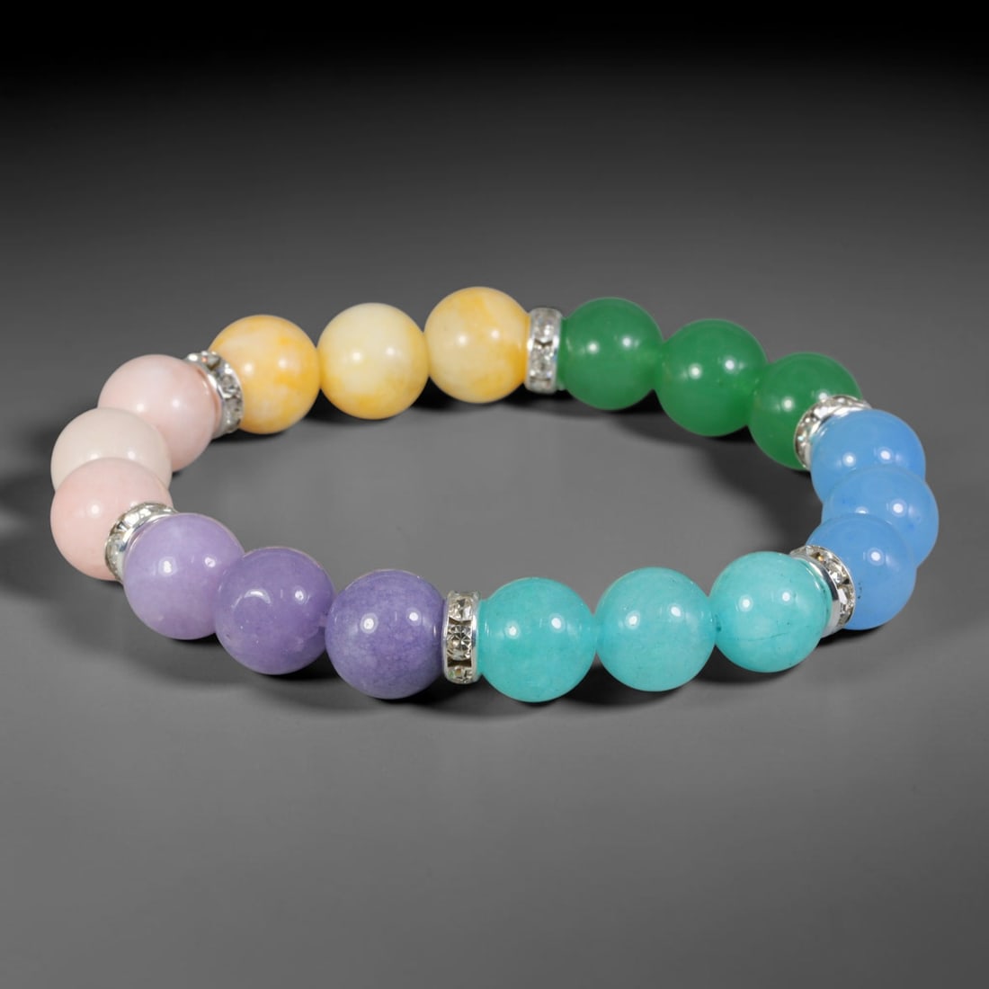 Natural Mixed Stone Beaded Bracelet - Polished Round Bead Strand, 35YM: This elastic stretch bracelet is made up of uniformly spherical polished natural mineral beads separated by silvered metal spacers set with clear crystalline accents. The hard stone features soft past