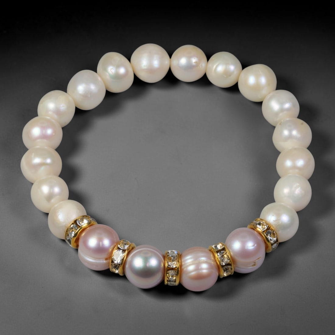 Natural Freshwater Pearl Beaded Bracelet - 9mm Baroque Pearl Strand, 43YM: This elastic stretch bracelet is crafted with 9mm natural freshwater baroque pearls, accented with gold-toned metal rhinestone spacers placed between select pearls. Each genuine freshwater pearl holds