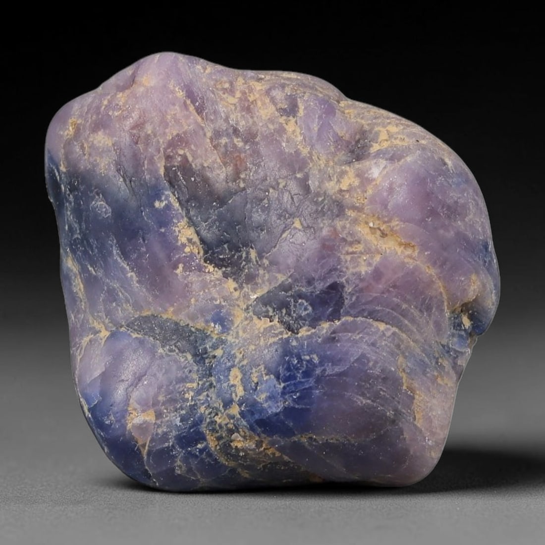 29ct Natural Unheated Sri Lankan Purplish Blue Sapphire Rough, 59YQ: This natural corundum rough is an unheated purplish blue sapphire sourced from Sri Lankan alluvial gem deposits, featuring an irregular natural native form with residual pale yellow-brown mineral matr