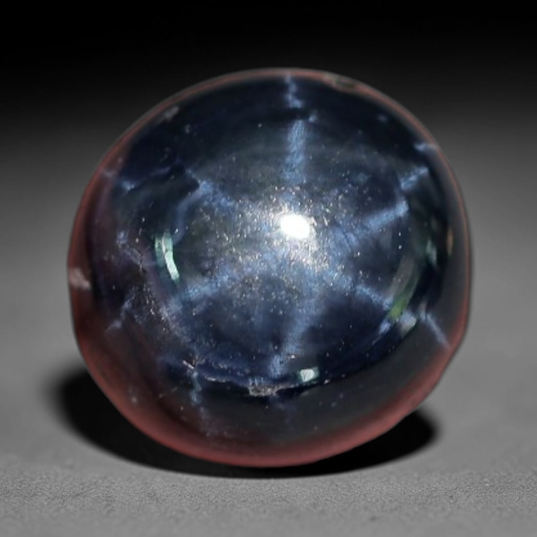 5.59 Carats Deep Blue Star Sapphire Round Cabochon - Natural Loose Gemstone, 7XC: This substantial round cabochon star sapphire features a rich, deep indigo hue, creating a dramatic backdrop for its vivid six-rayed star. The star's bright, well-defined rays radiate outward like cel