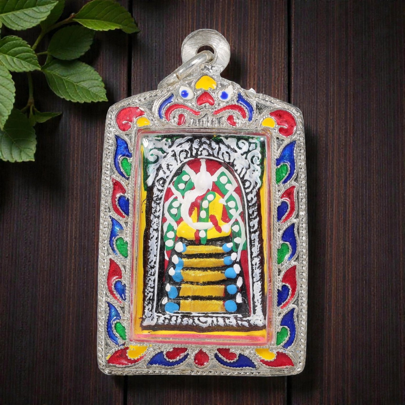 Thai Phra Somdej Amulet - Colorful Enamel Silver Tone Pendant, 67ZB: A Thai Buddhist Phra Somdej amulet featuring a stylized Buddha figure with tiered bases, housed in a silver-tone metal casing with vibrant multicolored enamel detailing. The glass-fronted enclosure pr
