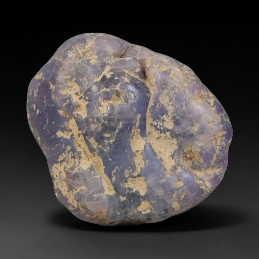 20ct Natural Unheated Sri Lankan Purplish Blue Sapphire Rough, 63YQ: This natural corundum rough is an unheated purplish blue sapphire sourced from Sri Lankan alluvial gem deposits, featuring an irregular natural native form with residual pale yellow-brown mineral matr