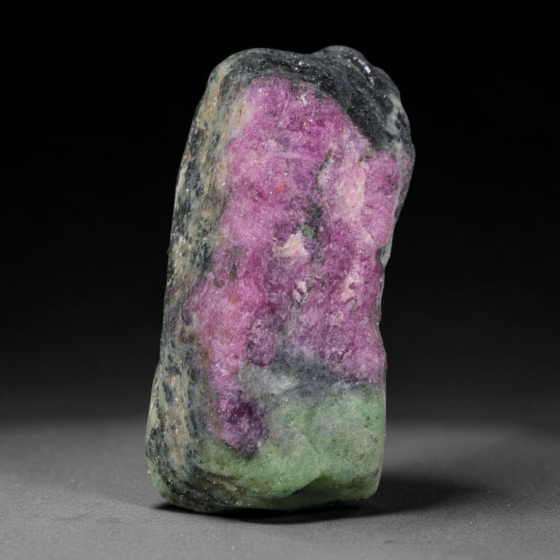 84ct Natural Tanzanian Ruby Zoisite Raw Rough Specimen Mineral Stone, 3YQ: This unpolished mineral rough is natural ruby zoisite sourced from Tanzania, exhibiting distinct banded mineral segregation of vibrant green zoisite, magenta ruby crystals, and dark hornblende inclusi