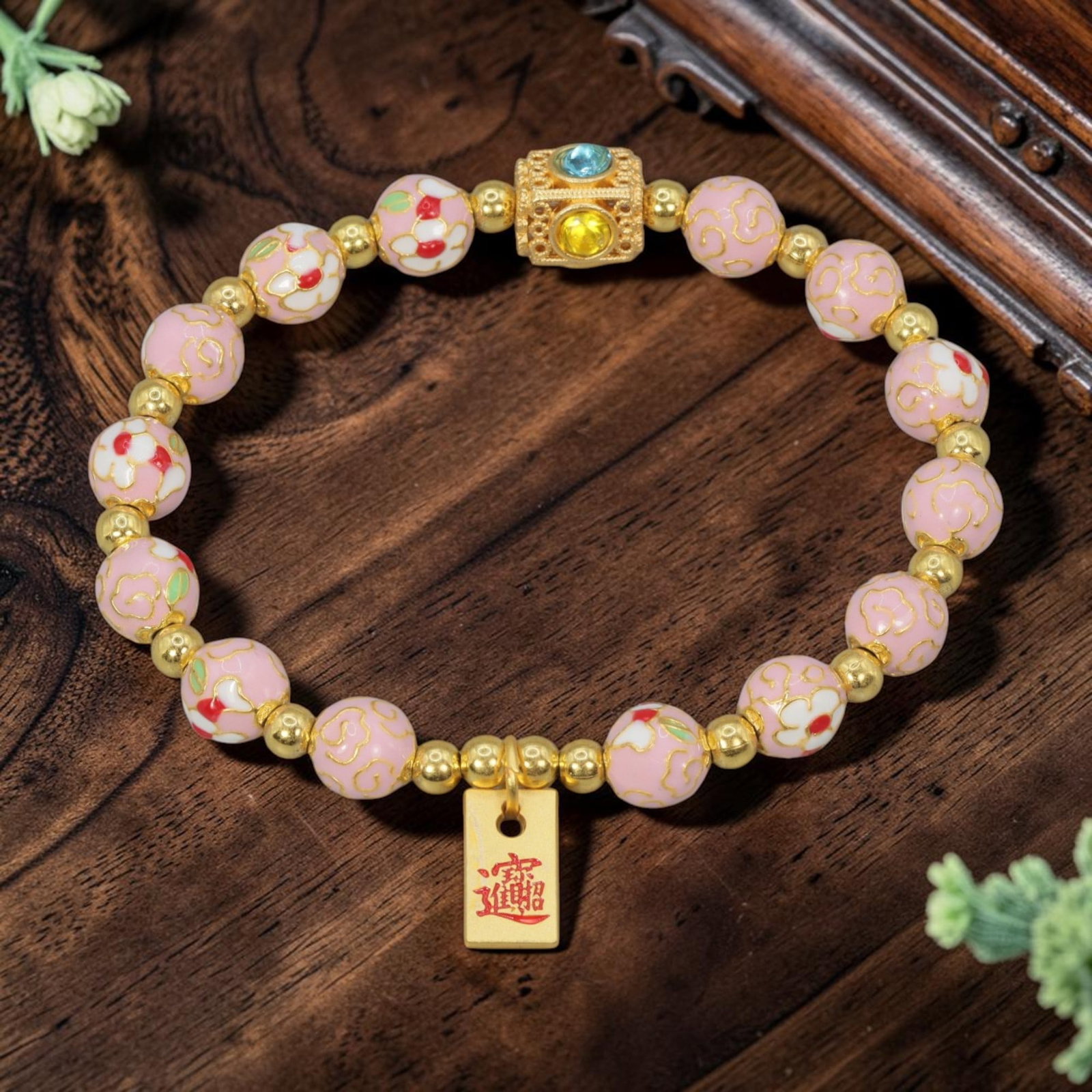 A Chinese Cloisonne Enamel Beaded Bracelet - Pink Gold-Tone Wealth Charm, 35YJ: This modern Chinese-style bracelet features 9.72mm round cloisonne enamel beads in a soft pink hue, alternating between white floral motifs accented with red and green enamel, and delicate gold cloud 