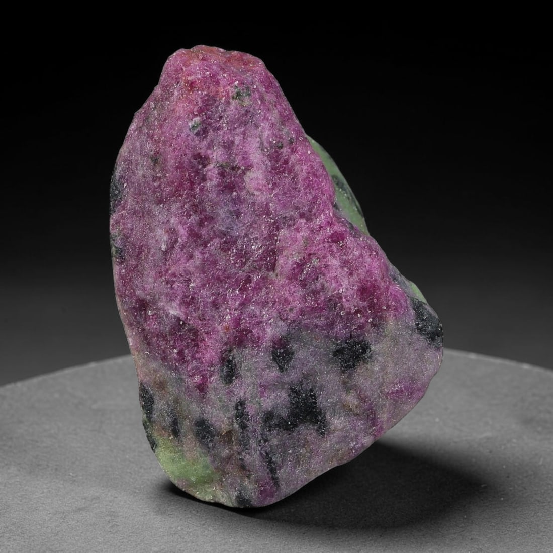87ct Natural Tanzanian Ruby Zoisite Raw Rough Specimen Mineral Stone, 100YK: This unpolished mineral rough is natural ruby zoisite sourced from Tanzania, exhibiting distinct banded mineral segregation of vibrant green zoisite, magenta ruby crystals, and dark hornblende inclusi