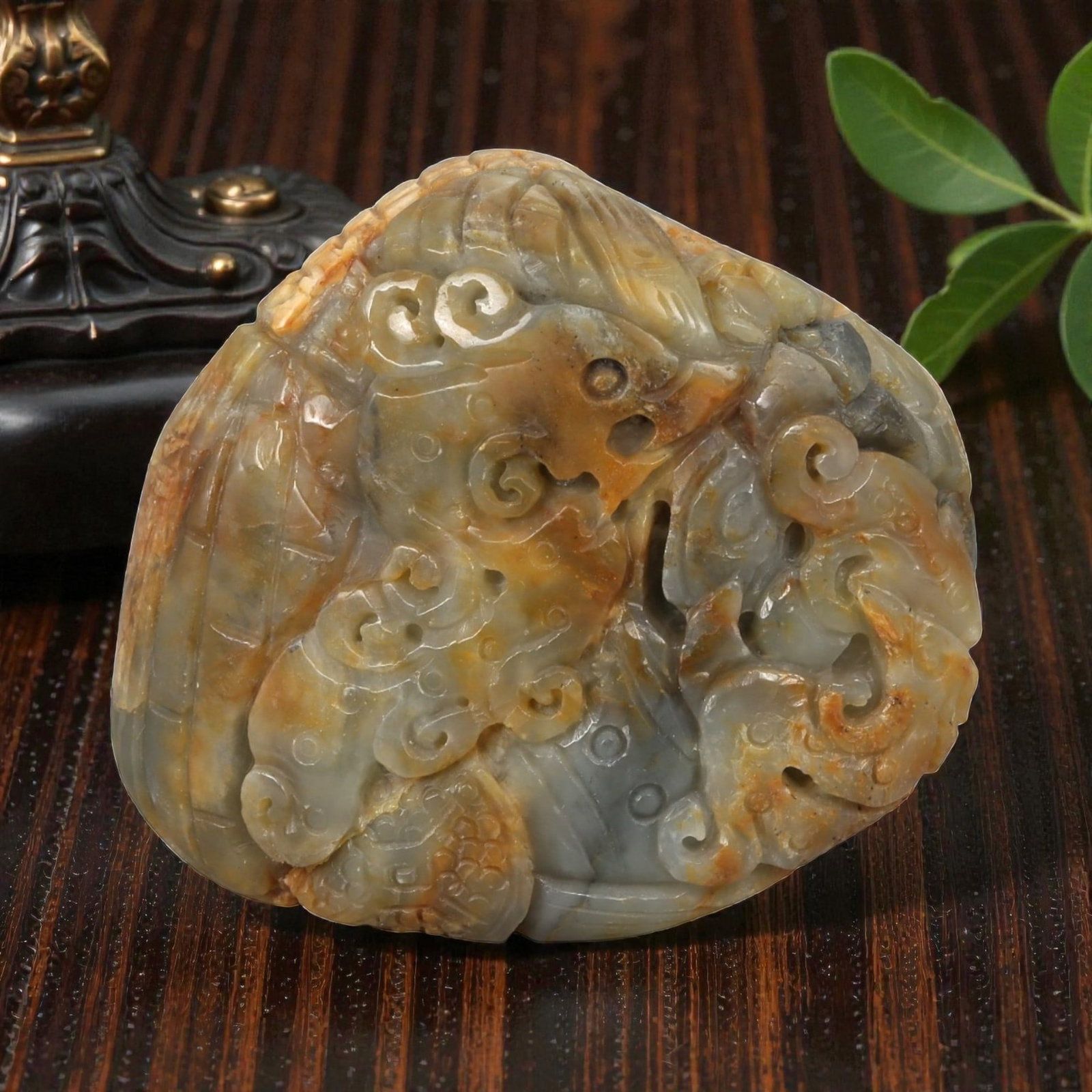 A Chinese Hetian Nephrite Jade Dragon Carving, 20th Century, 7YB: Carved from grey-green Hetian nephrite jade with areas of warm brown and russet inclusions, the object is worked as a compact sculptural composition depicting a dragon in relief. The creature is shown
