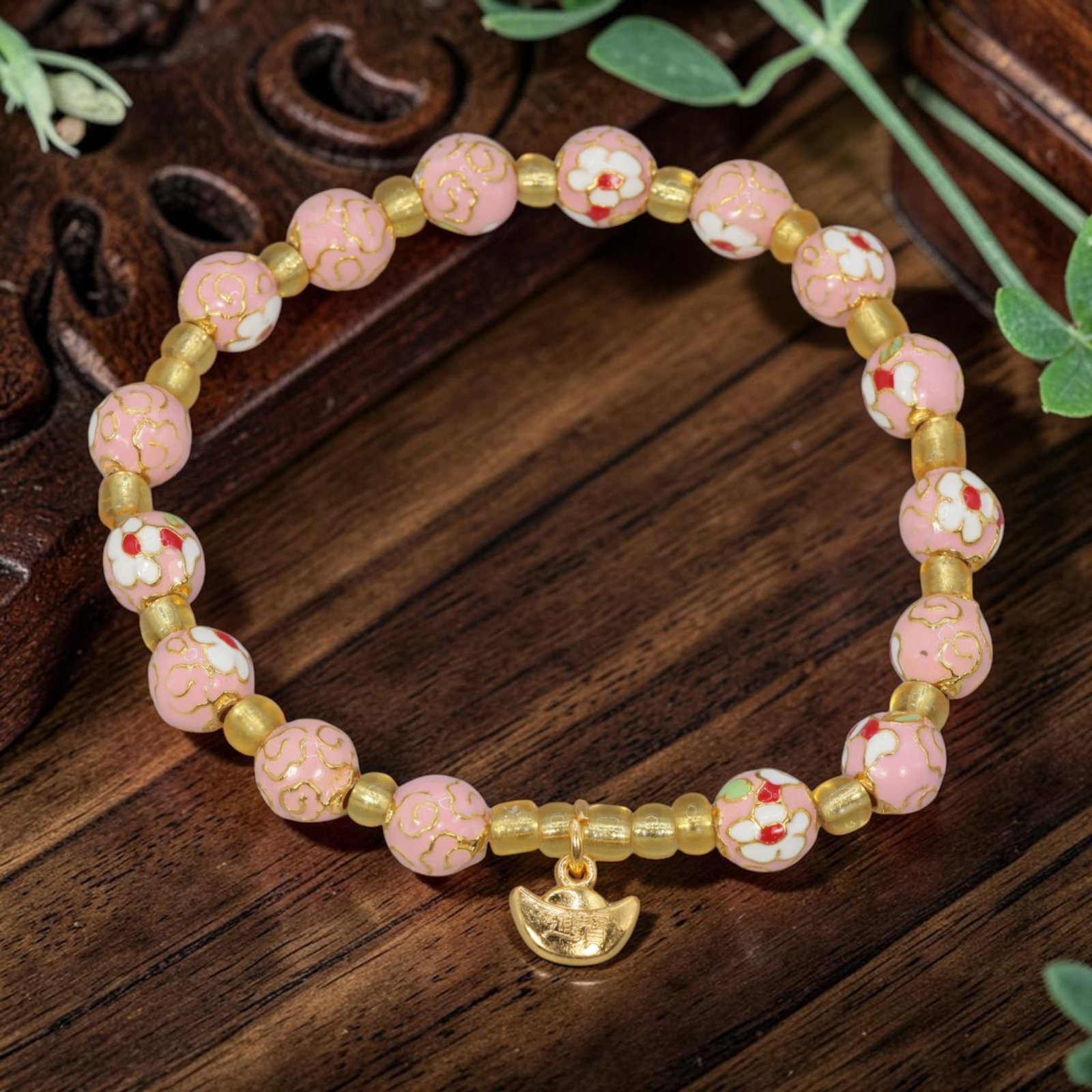 A Chinese Cloisonne Enamel Beaded Bracelet - Pink Gold-Tone Ingot Charm, 42YJ: This modern Chinese-style bracelet features 7.66mm round cloisonne enamel beads in a soft pink hue, alternating between gold cloud patterns and delicate white floral motifs accented with red enamel. S
