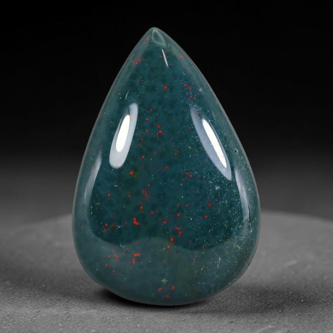 32.66 Carats Natural Bloodstone Teardrop Cabochon Gemstone, 32XZ: Come take a look at this lovely polished teardrop bloodstone with such striking natural speckled detail all over its face. This smooth domed pear cab measures 32.0x21.6x6.4mm and weighs 32.66 carats t