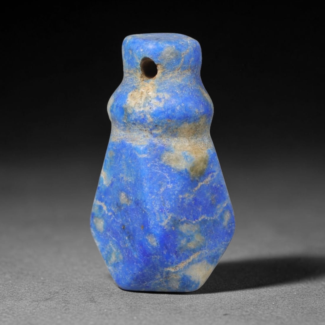 Ancient Lapis Lazuli Amulet - Near Eastern Carved Pendant, 27WT: Carved from natural lapis lazuli, this tapered pendant bears a distinct contoured silhouette characteristic of Near Eastern stonework, with natural pale mineral veining spread across its deep blue mat