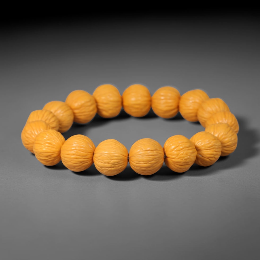 Rudraksha Seed Bracelet - Carved Buddhist Prayer Bead Strand, 60YM: This strand is constructed from naturally textured rudraksha seed beads, shaped into uniform barrel forms with intricate organic fissuring across each surface. The seeds display a consistent pale tan 