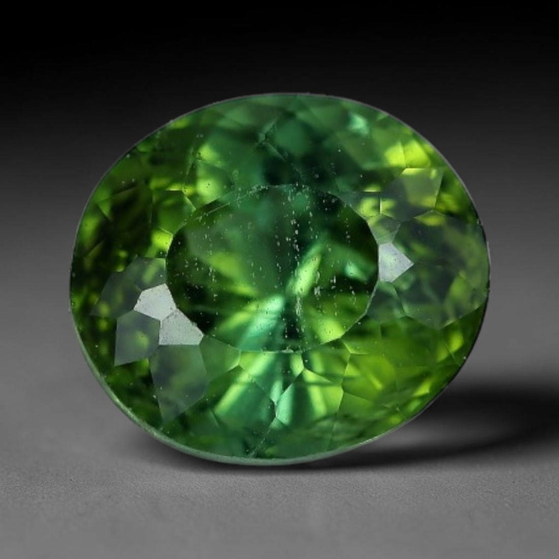 1.38 Carats Natural Green Tourmaline Oval Faceted Loose Gemstone, 73XZ: This specimen consists of natural tourmaline, finished with consistent faceting to facilitate light refraction through its crystalline body. The mineral holds rich green colour saturation with subtle 