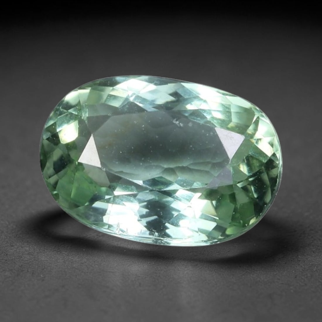 1.55 Carats Mint Green Tourmaline Oval Cut - Natural Loose Gemstone, 47XC: This luminous oval-cut tourmaline showcases a delicate, ethereal mint-green hue, reminiscent of sunlit seafoam or fresh spring foliage. Its crisp faceting creates a brilliant, sparkling play of light,